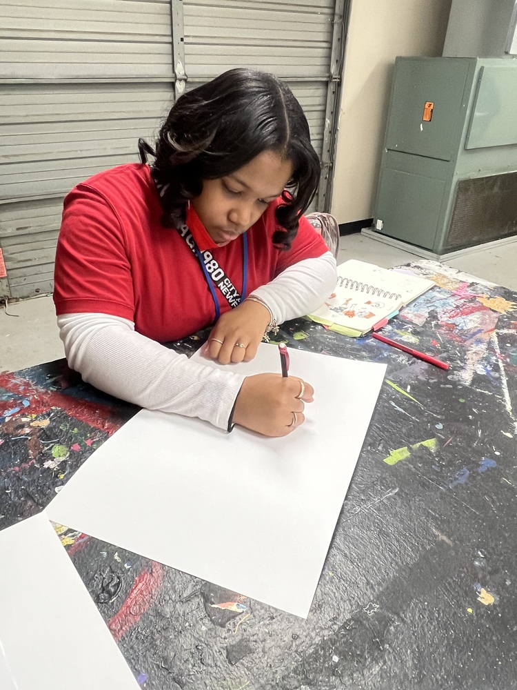 Turnage drawing in her sketchbook