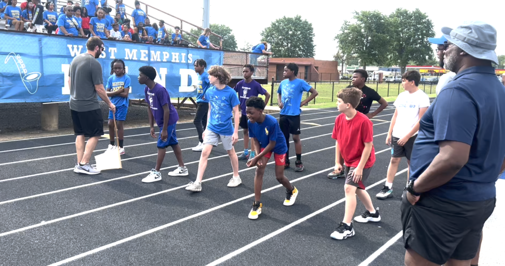 6th grade boys line up to run the 50 meter dash